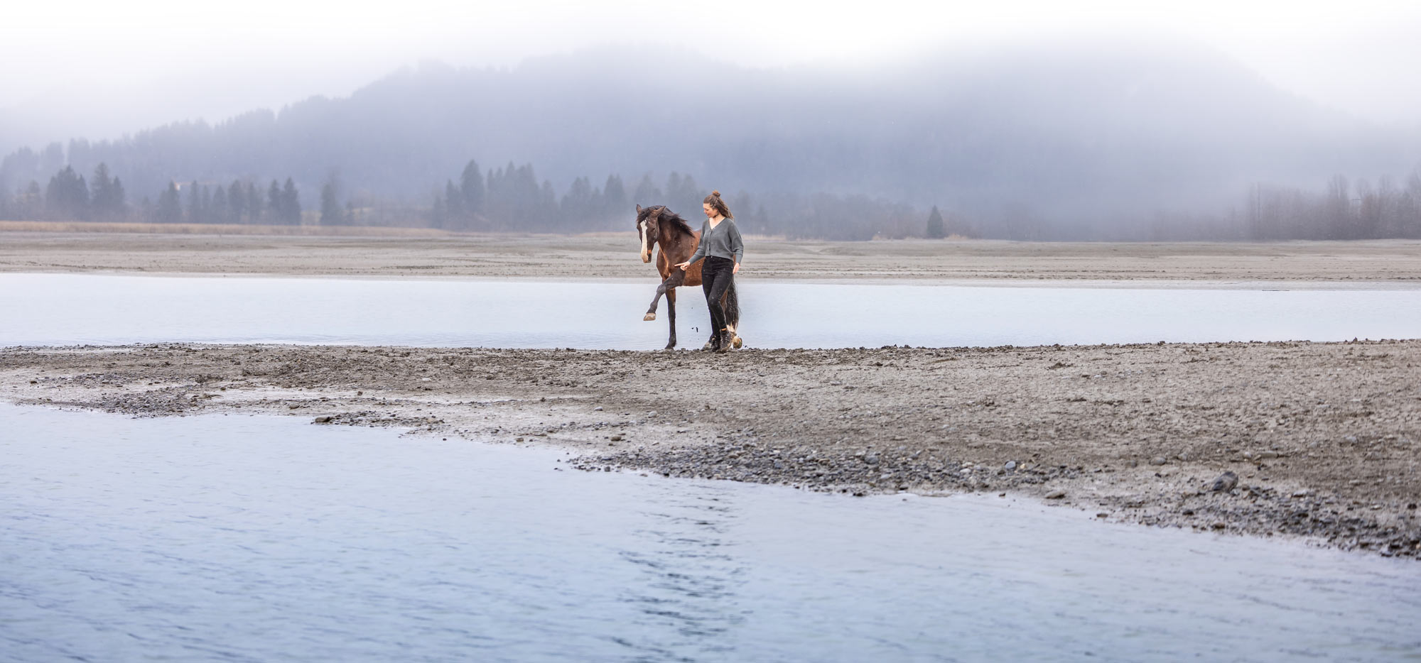 Pferde wollen artgerecht - Conny Hutter, BestTUPferd Beraterin für Stallbetreiber und Pferdebesitzer, gesundes Training Pferd und Besitzerin bei einem Ausflug am See. Nebel umhüllt den Berg im Hintergrund